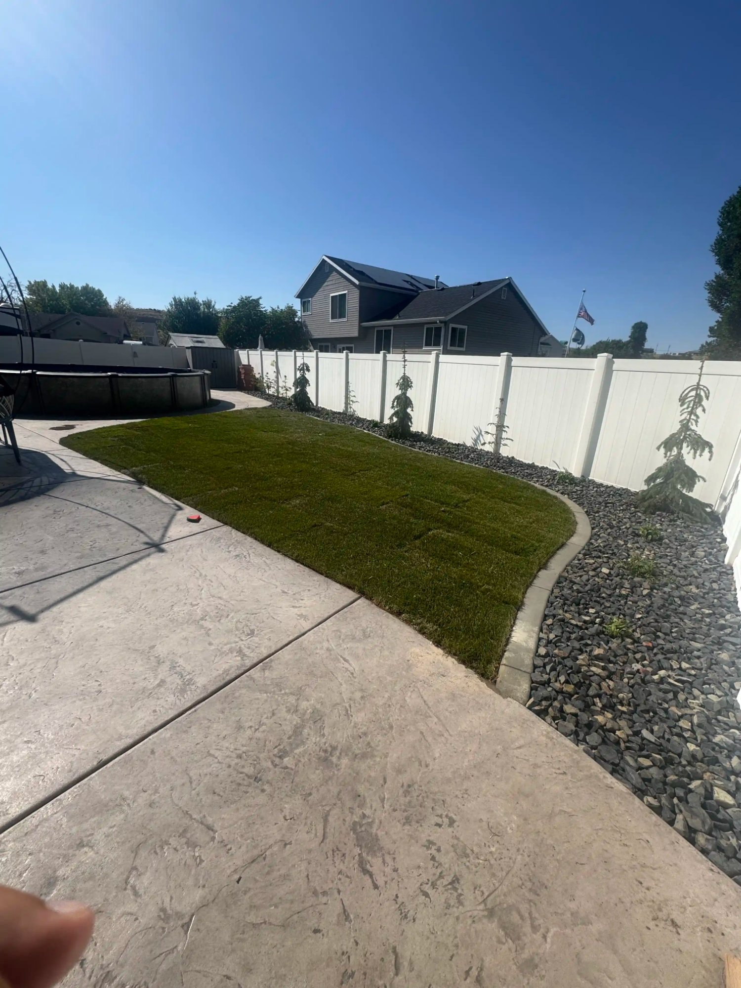 Backyard sod and rock border landscaping by EC Landscaping in Pleasant View Utah