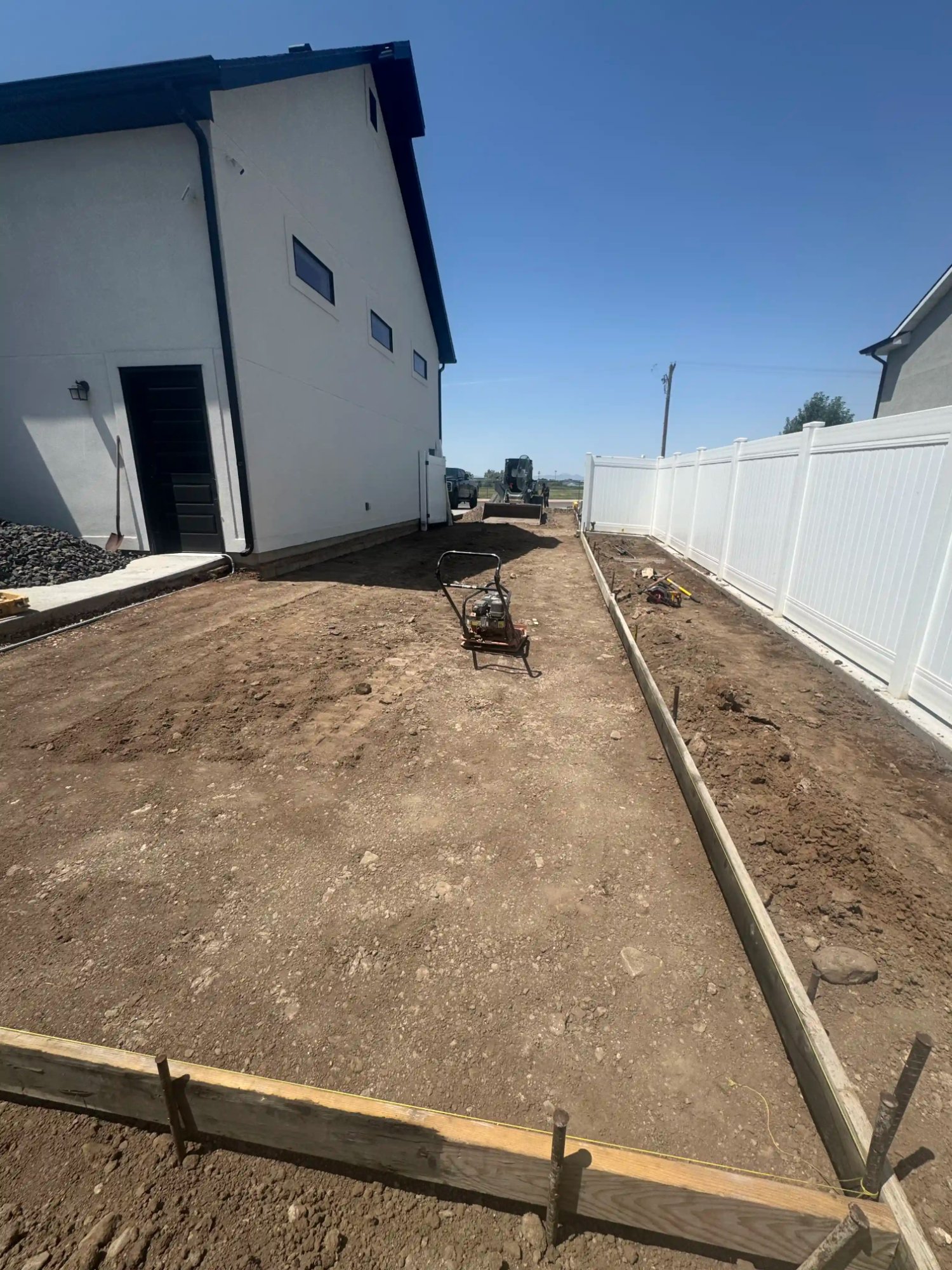 Concrete site prep with plate compactor and forms by EC Landscaping in Pleasant View Utah
