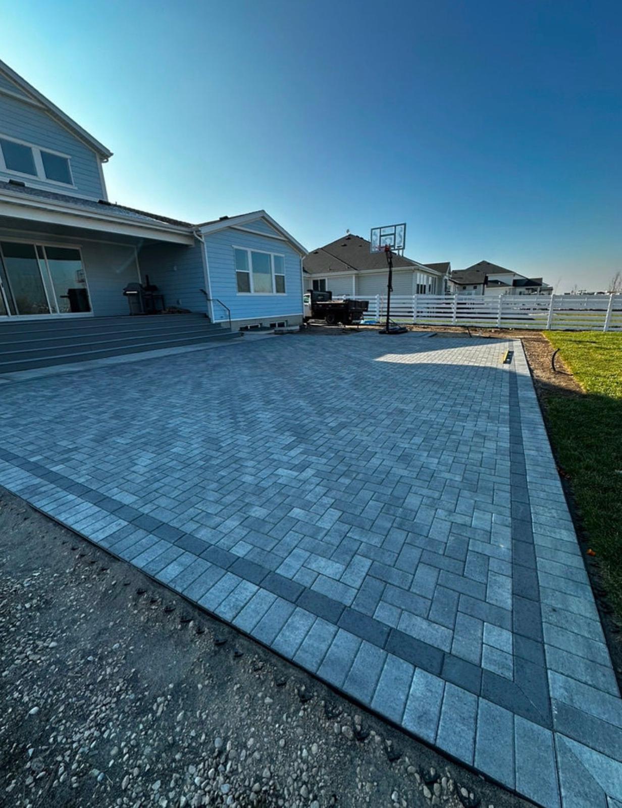 Backyard paver patio connecting to paver driveway, Northern Utah residential property