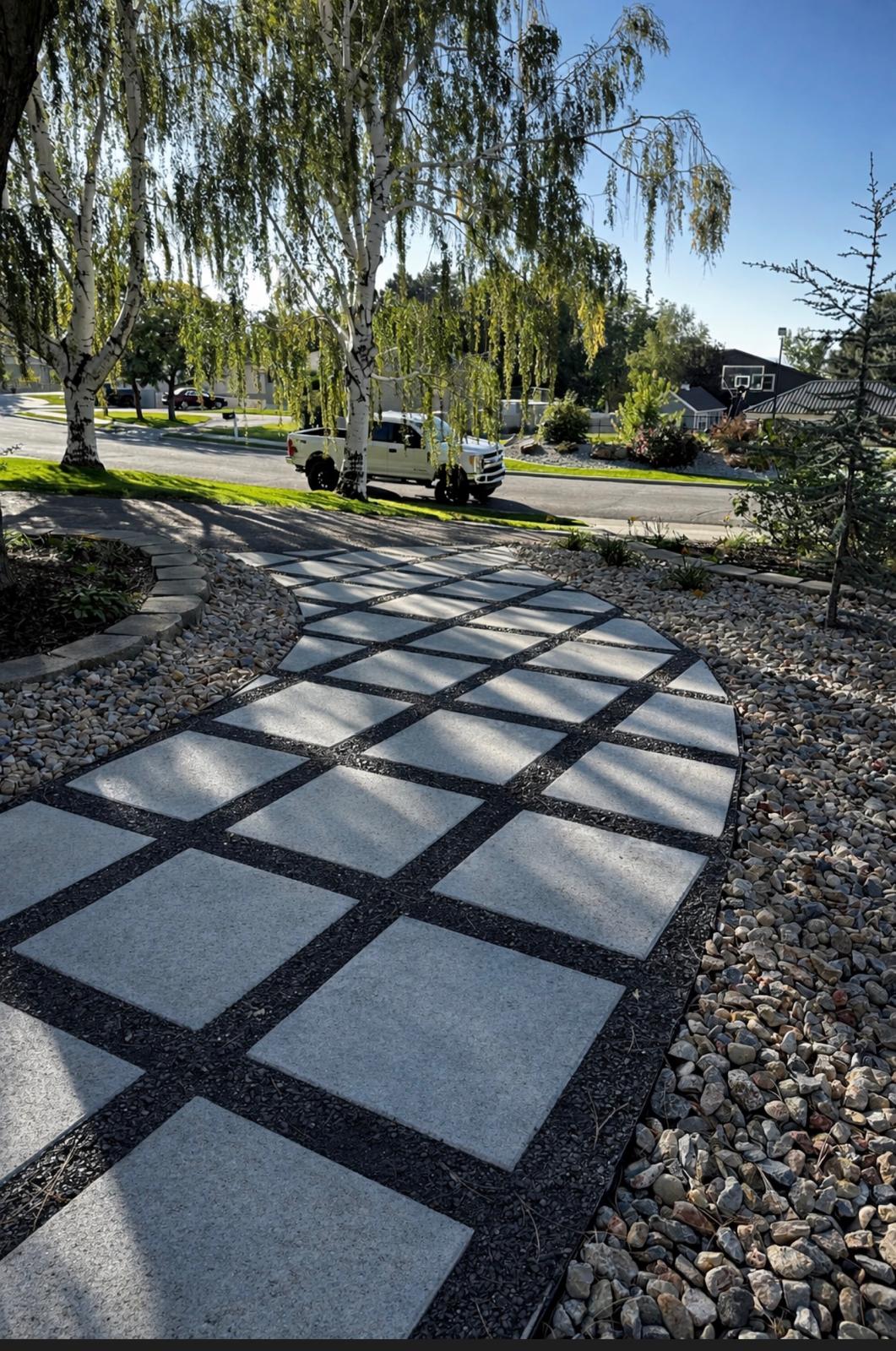 Grid pattern paver walkway between mature willow trees, Northern Utah landscape design